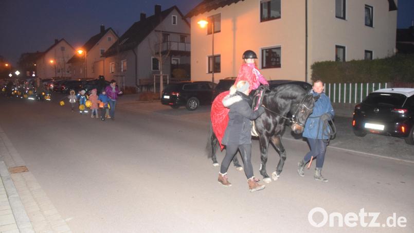 In großem Abstand folgen die Kinder mit ihren Laternen Anna Lochner, die als Sankt Martin verkleidet auf dem Pferd saß. Bild: fz
