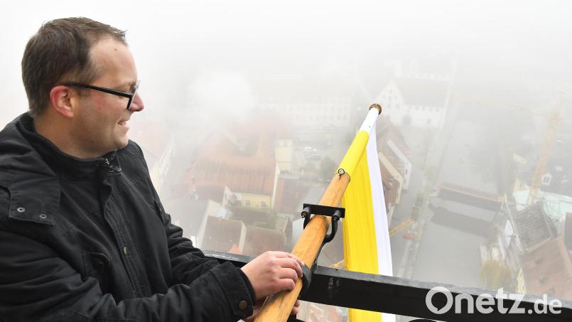 Pfarrer Thomas Helm richtet anlässlich des Patroziniums eine der vier weiß-gelben &quot;Zachäusfahnen&quot; am Turm der Martinskirche aus. Bild: Petra Hartl