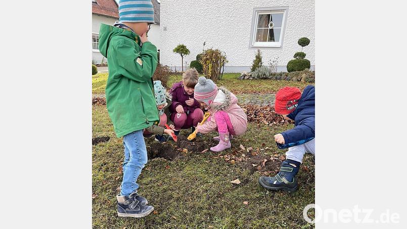Mit Begeisterung waren die Kinder bei der Pflanzaktion bei der Sache. Das Ergebnis wird im Frühjahr eine blühende Ortsmitte sein. Bild: lgc