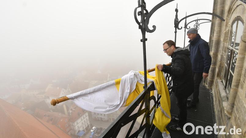 Neblig war&#039;s am Donnerstagmorgen und auch ziemlich kalt in luftiger Höhe auf dem Martinsturm. Am Geländer des Umgangs unterhalb der Uhr gibt es eiserne Befestigungen, in denen die großen Fahnen sicher fixiert werden können. Bild: Petra Hartl