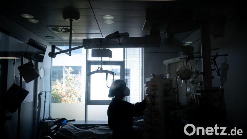 Eine Mitarbeiterin der Pflege steht in einem Zimmer einer Corona-Intensivstation. Bild: Fabian Strauch/dpa