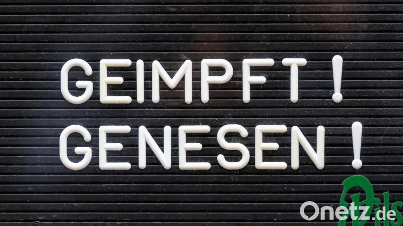 „Geimpft! Genesen!“ steht auf einem Schild an einer Bar. Bild: Robert Michael