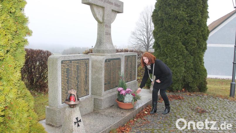 Bürgermeisterin Marina Hirnet legt am Kriegerdenkmal eine Blumenschale nieder. Bild: pi