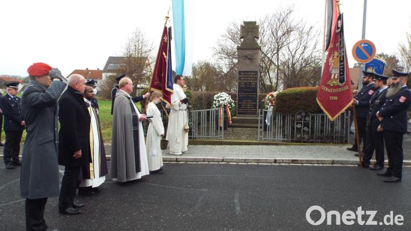 Kommandeur Sebastian Erbe, Bürgermeister Roland Strehl und Pfarrer Wolfgang Bauer (von links) sowie eine Abordnung der Feuerwehr Gärmersdorf beim Abspielen Nationalhymne beim Volkstrauertag in Kümmersbruck. Bild: e