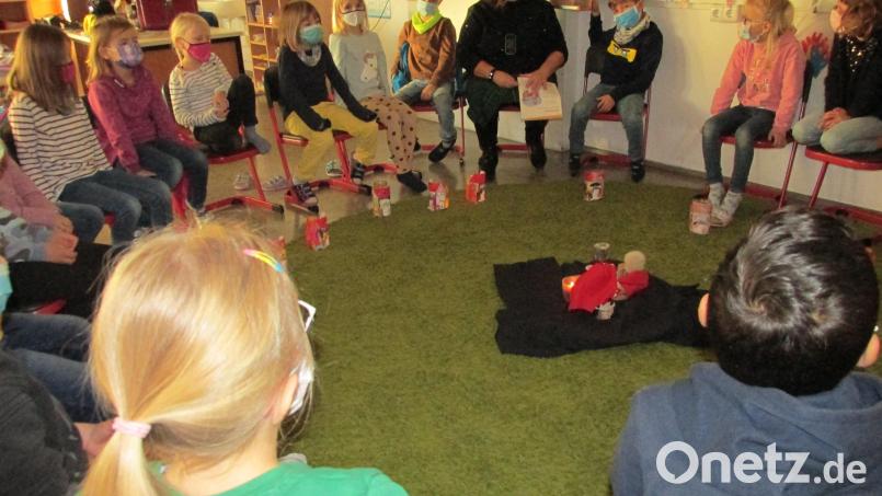 Im Kreis versammelten sich die Schüler um Figuren des Bettlers und des heiligen Martin. Bild: Grundschule Immenreuth/exb