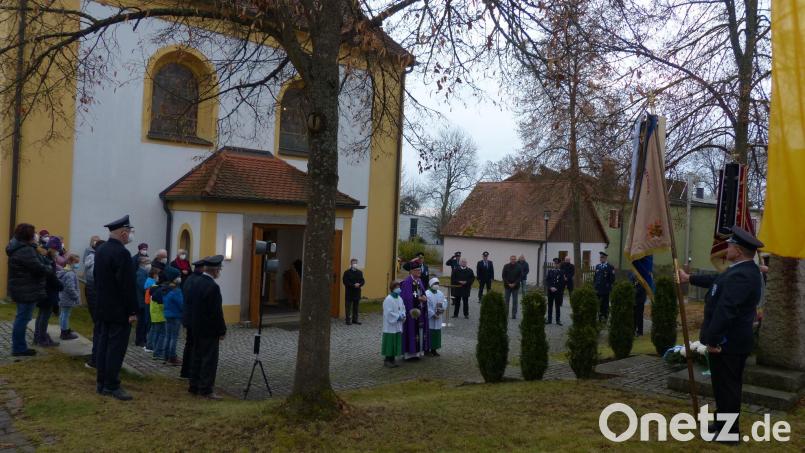 Zur Gedenkfeier zum Volkstrauertag versammelten sich die Teilnehmer zwischen Kriegerdenkmal und Kirche in Neudorf. Bild: hme