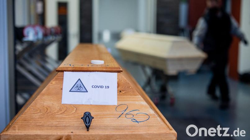 Ein Sarg mit einem Verstorbenen mit der Aufschrift &quot;Covid 19&quot; und dem Zeichen &quot;Biohazard&quot; wird von einem Bestatter in ein Krematorium eingeliefert. Symbolbild: Rolf Vennenbernd