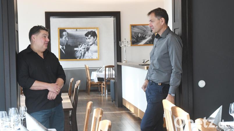 Im Hintergrund flirten Humphrey Bogart und Audrey Hepburn. Viel mehr Deko ist in den Gaststuben der Aichinger-Villa derzeit nicht zu finden. Die bildlichen Filmzitate passen zum Geschäftsmodell der neuen Pächter James Bouchie (links) und Alexander Schwarz. Bild: Gabi Schönberger