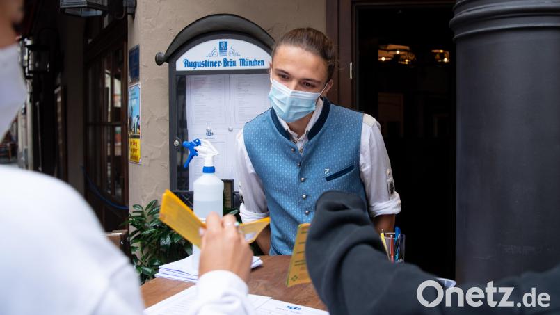 Ein Mitarbeiter eines Wirtshauses kontrolliert am Eingang seine Gäste. Künftig gilt auch in der Gastronomie in Bayern 2G. Bild: Sven Hoppe