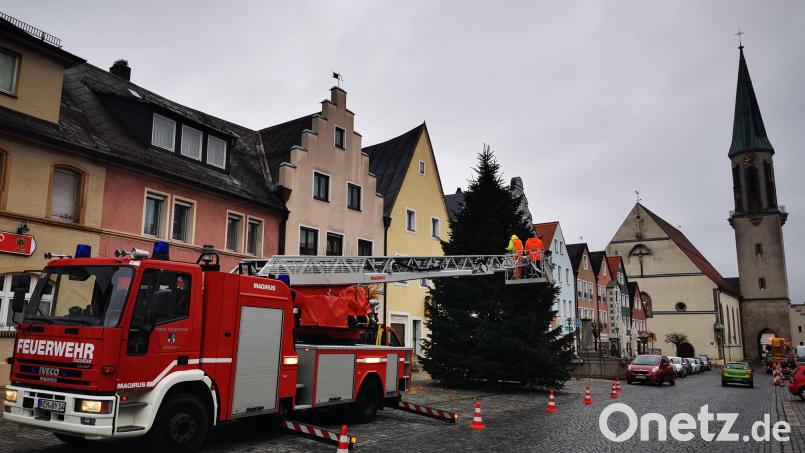 Eine stattliche Nordmanntanne ziert den Kemnather Stadtplatz in dieser Weihnachtszeit. Ein Trupp der Feuerwehr Kemnath mit der Drehleiter und Mitarbeiter des städtischen Bauhofs sorgten am Donnerstagvormittag dafür, dass die Lichter am Weihnachtsbaum erstrahlen können. Bild: mde