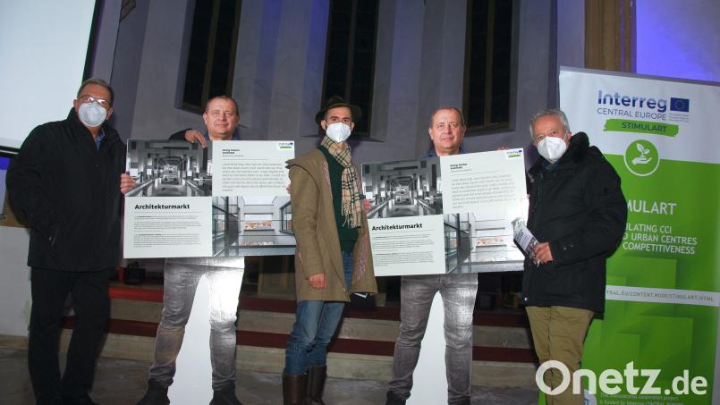 Die Herren mit den Masken sind echt (von links): Bürgermeister Martin Preuß, Projektleiter Florian Gröninger und Kulturreferent Fabian Kern ) bei der Vernissage in der Spitalkirche mit zwei „Ausgaben“ von Architekt Georg Zunner. Bild: gsp