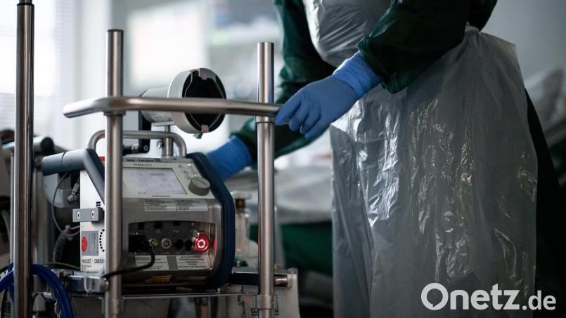 Eine Mitarbeiterin der Pflege steht in einem Zimmer einer Corona-Intensivstation. Bild: Fabian Strauch/dpa