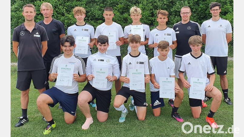 Das Trainerteam des DFB-Stützpunktes Schwarzenfeld, Christian Most (links), Florian Tausendpfund (Zweiter von links) und Oliver Eckl (rechts) verabschiedete die altersbedingt ausscheidenden Spieler sowie Zusatztrainer Christian Hechtl (stehend Zweiter von rechts). Bild: exb