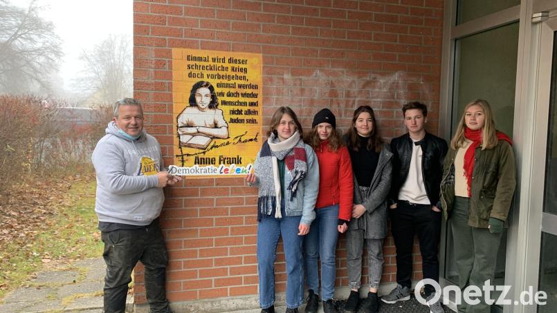 Die Theatergruppe des Otto-Hahn-Gymnasiums mit Künstler Nils Oskamp (links) vor dem fertigen Graffiti-Kunstwerk. Bild: Otto-Hahn-Gymnasium/exb