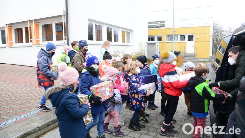 Philipp Koch (rechts) vom Serviceclub &quot;Round Table&quot; verstaut die rund 50 Päckchen aus der Grundschule Schirmitz in seinem Kombi. Bild: bey