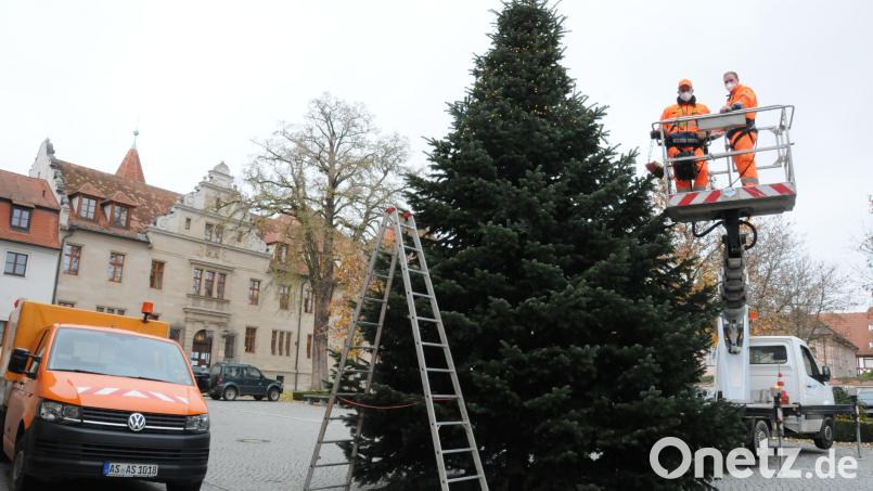 Zwei Mitarbeiter des Bauhofs haben den Weihnachtsbaum im Innenhof mit Lichterketten geschmückt. Bis vor kurzem stand der Baum noch in Köfering. Bild: Christine Hollederer/exb