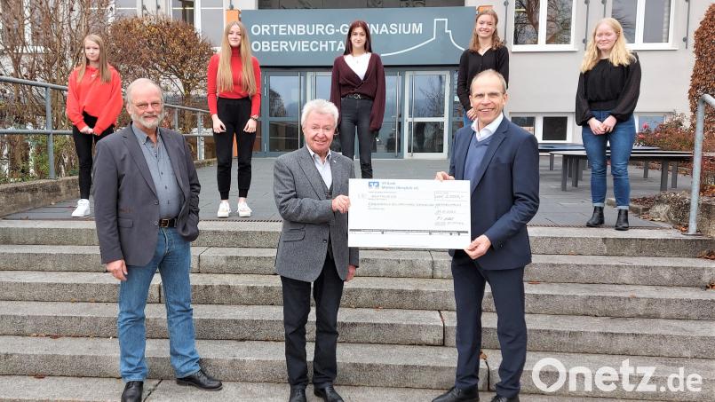 Schulleiter Ludwig Pfeiffer (rechts) und Ulrich Wohlgemuth vom Förderverein Ortenburger (links) freuen sich mit den Schülerinnen im Hintergrund über die Spende von Michael Koller, Gesellschafter der MMM Group. Bild: lg
