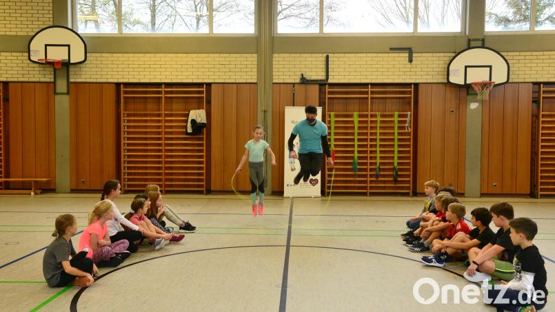 Anton Habla von der Deutschen Herzstiftung übt in der Turnhalle der Grundschule Schirmitz mit den Kindern unterschiedliche Varianten des Seilspringens ein. Bild: bey