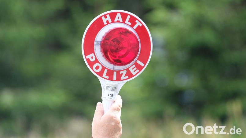 Eine Polizistin hält während einer Polizeikontrolle eine rote Winkerkelle in die Höhe. Archivbild: Sebastian Willnow/dpa