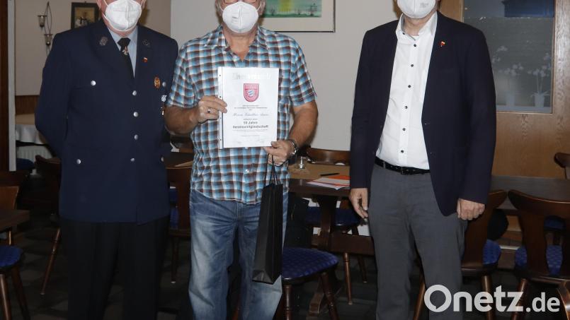 Vorsitzender Günther Aures (links) überreicht gemeinsam mit Bürgermeister Michael Göth (rechts) die Urkunde für 50 Jahre Mitgliedschaft an Günther Aures. Bild: mfh