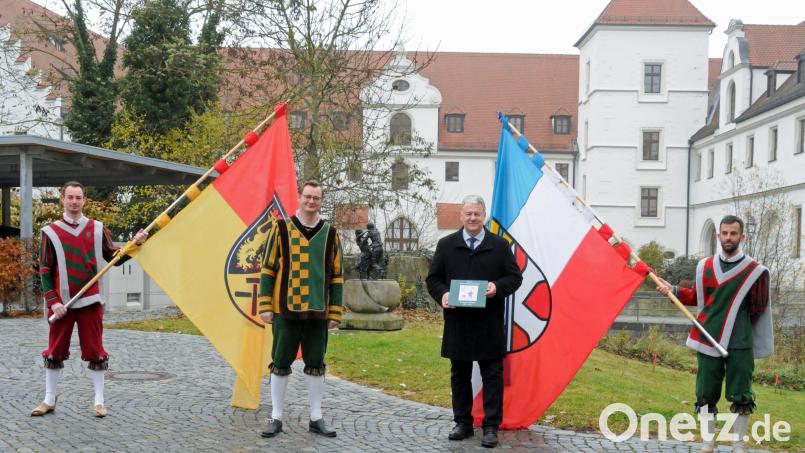 Die Fahnenschwinger Johannes Piehler, Peter Kick und Johannes Hager (von links) überreichten die Chronik an Landrat Richard Reisinger. Bild: Christine Hollederer/exb