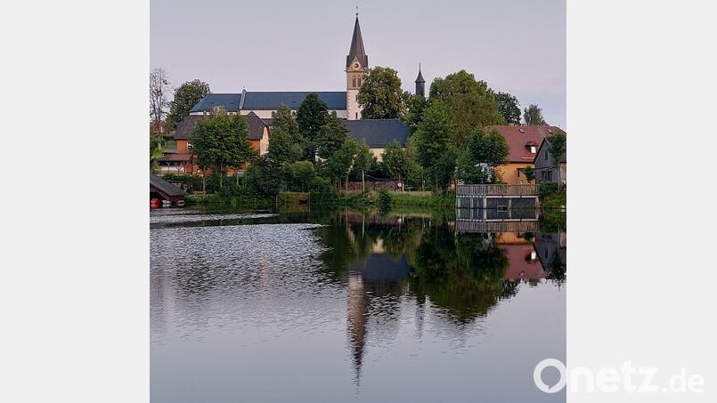 Es ist ein Motiv für eine Ansichtskarte, wenn sich die Silhouette von Nagel mit dem alles überragenden Kirchturm im Nageler Weiher spiegelt. Auch der Turm der ersten Kirche ist zu sehen. Bild: ld