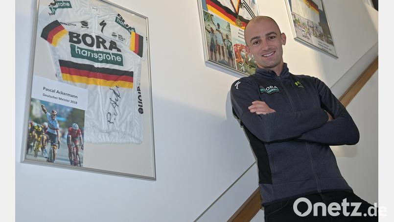 An einer Wand im Fahrradgeschäft seiner Familie hat Andreas Schillinger einige besondere Andenken an seine Radsport-Karriere aufgehängt. Unter anderem seine beiden Goldmedaillen und Meistertrikots der deutschen Bergmeisterschaften 2017 und 2019 sowie ein unterschriebenes Trikot von Pascal Ackermann (links). Bild: ref