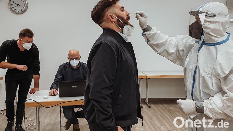 Probedurchlauf: Noah Lugert macht bei Bürgermeister Sebastian Dippold einen Antigen-Schnelltest. Bereitschaftsleiter Sebastian Windschügl (sitzend) weist Stefan Plößner von der Neustädter Feuerwehr ein. Bild: Stadt Neustadt/WN/exb