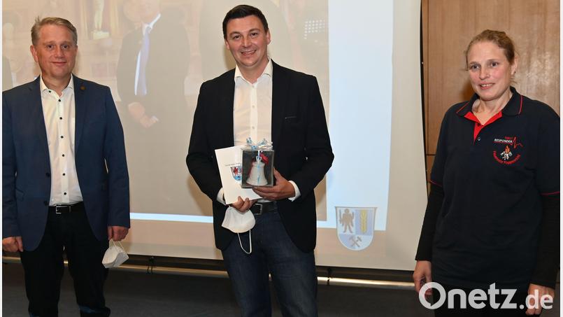 Mit einem Geschenk bedankt sich Bürgermeister Hermann Böhm (links) bei Michael Schröter (Mmitte), der als Lebensretter schon mit der Christophorus-Medaille ausgezeichnet worden ist. Stolz ist auch Silke Kunz (rechts), die Vorsitzende des Fördervereins für die First Responder Poppenricht, denn Michael Schröter will sich auch künftig als First Responder für die Rettung anderer einsetzten. Bild: gf