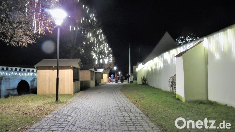 Größer hätte der Kontrast kaum sein können: Leere Weihnachtsbuden und glanzvolle Beleuchtung. Dennoch wollten einige Besucher bei der Aktivierung der Lichter am Fischhof und der Brücke dabei sein. Bild: ubb