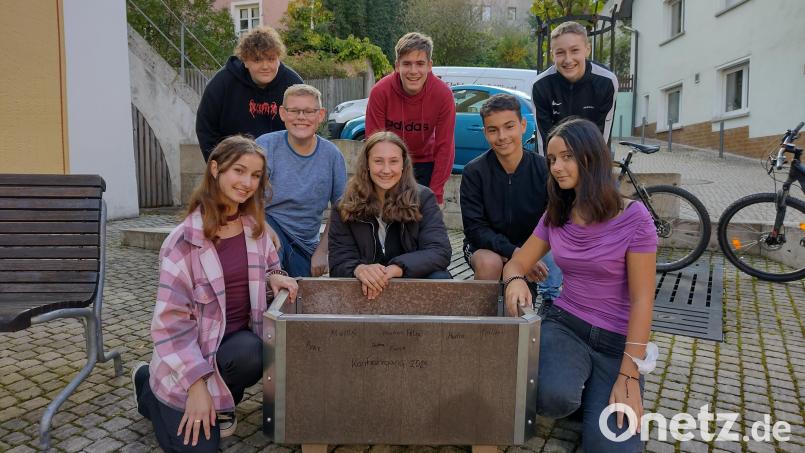 Bei der Spendenübergabe (von links) Fiona, Marius, Philipp, Sophia, Felix, Bastian, Marlon und Anne verewigten sich auf dem von ihnen gestifteten Blumentrog mit ihrem Namen. Bild: wku