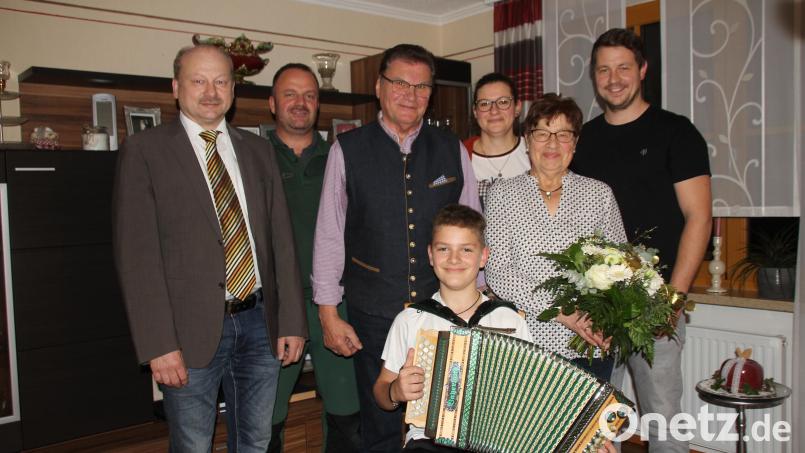 Zur Goldenen Hochzeit spielte dem Jubelpaar Franziska und Michael Weber Enkel Simon (vorne) auf seiner Harmonie ein Ständchen. Neben vielen weiteren Gratulanten, darunter auch Feriengäste, sprachen auch (von links) Zweiter Bürgermeister Robert Hechtl, Schwiegersohn Marco, Tochter Michaela und Gemeinderat Matthias Meier Glückwünsche aus. Bild: frd