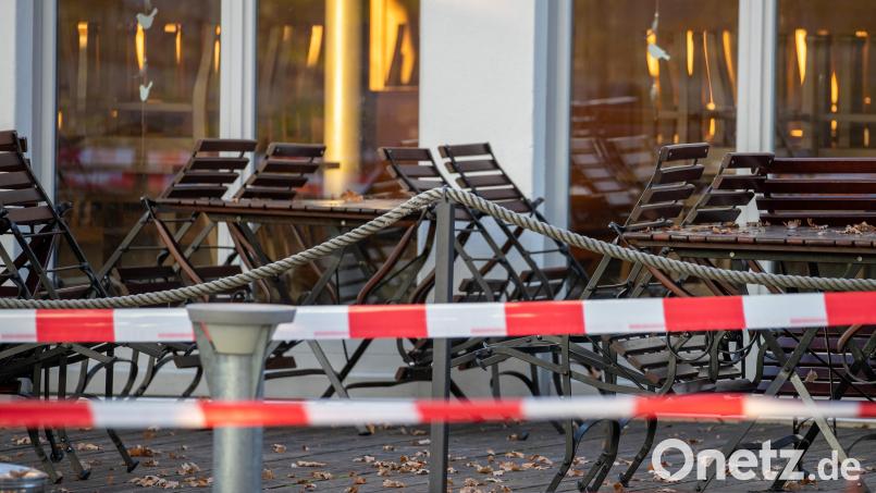 Mit Flatterband sind Tische und Stühle eines geschlossenen Biergartens abgesperrt. Seit Wochenbeginn gilt in Deutschland ein Teil-Lockdown. Bild: Daniel Karmann