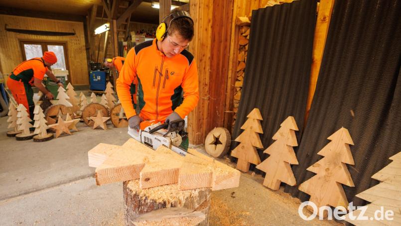 Alexander Schirbel, Auszubildender am Forstbetrieb Fichtelberg, schnitzt mit der Motorsäge einen kleinen Weihnachtsbaum aus Holz Bild: Martin Hertel/exb