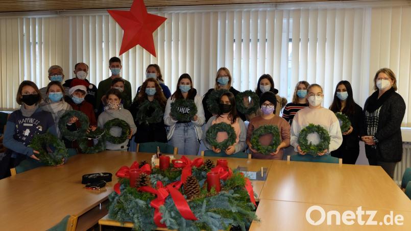 Die am Adventskranzbinden beteiligten Kinder und Jugendlichen der Mittelschule Mitterteich zusammen mit Rektorin Gisela Kastner (rechts). Auch für das Lehrerzimmer wurde ein Kranz angefertigt. Bild: Mittelschule Mitterteich/exb