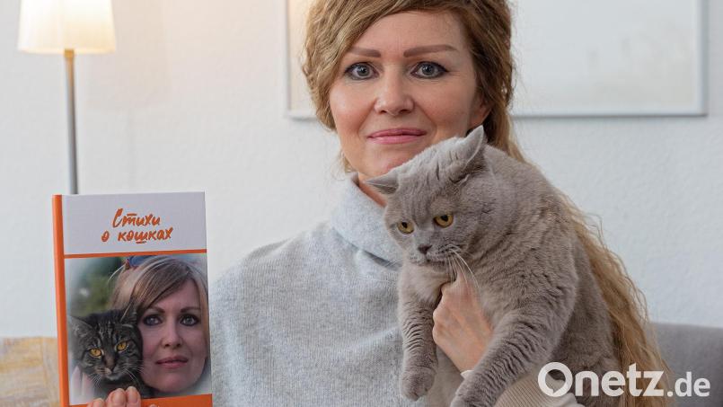 Katze Vivian schaut auf das Buch in Frauchens Hand, schließlich spielt der Samtpföter zusammen mit Artgenosse Fifina darin eine große Rolle. Liliya Geiss hat in ihrem ersten Gedichtband „Katzen-Verse“ auch die Erlebnisse mit ihren beiden Stubentigern humorvoll verarbeitet. Bild: Michael C. Geiss