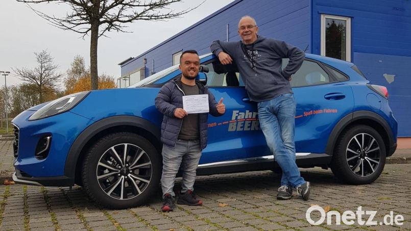 Endlich geschafft! Michael Mikolaj präsentiert stolz mit seinem Fahrlehrer das Ergebnis seiner Führerscheinprüfung: bestanden. Die Prüfung legte der 31-Jährige wegen seiner Kleinwüchsigkeit bei einer Fahrschule in der Nähe von Bremen ab. Bild: Mikolaj / exb