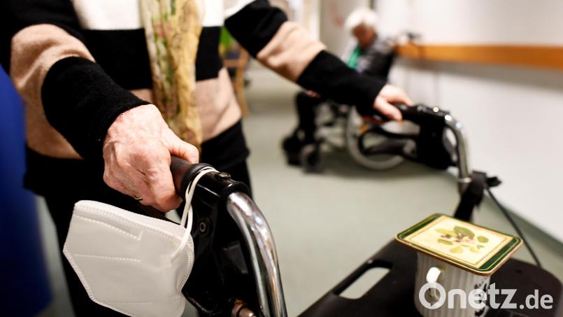 Eine Heimbewohnerin schiebt ihren Rollator mit FFP-2 Maske durch einen Gang in einem Altersheim. Im Altenheim in Waldsassen haben sich fünf Bewohner mit dem Coronavirus infiziert. Symbolbild: Angelika Warmuth/dpa