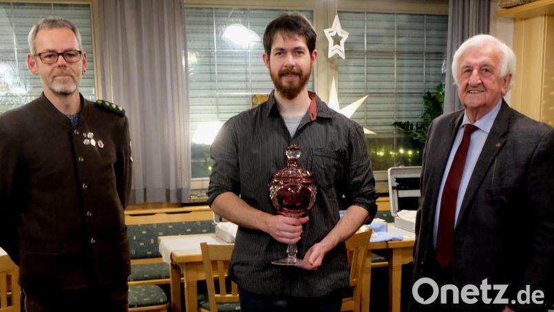 Schützenmeister Siegfried Kellner (links) und Fred Lehner (rechts) überreichen den Pokal an Dominik Kraus. Bild: le