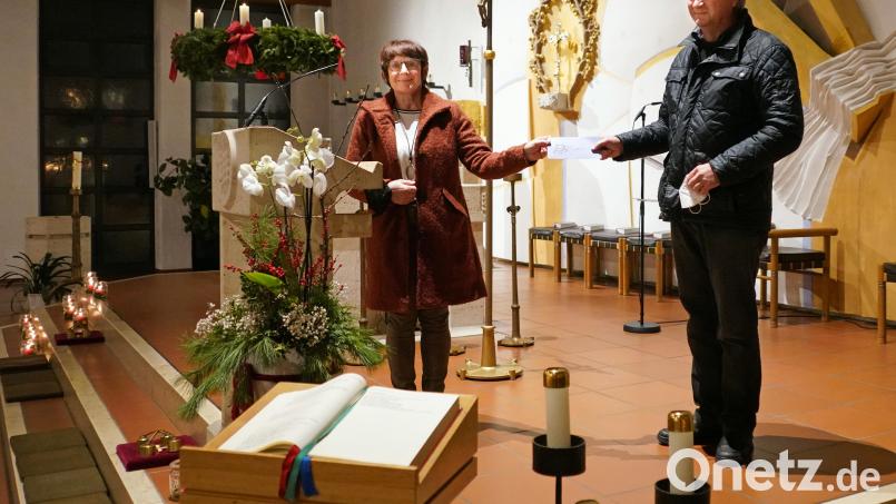 Frauenbundvorsitzende Sieglinde Zielbauer (links) übergibt nach der Adventsandacht eine Spende von 1000 Euro an Franz Wittmann, der sich seit 35 Jahren um das Missionskonto für Schwester Diane kümmert. Bild: fvo