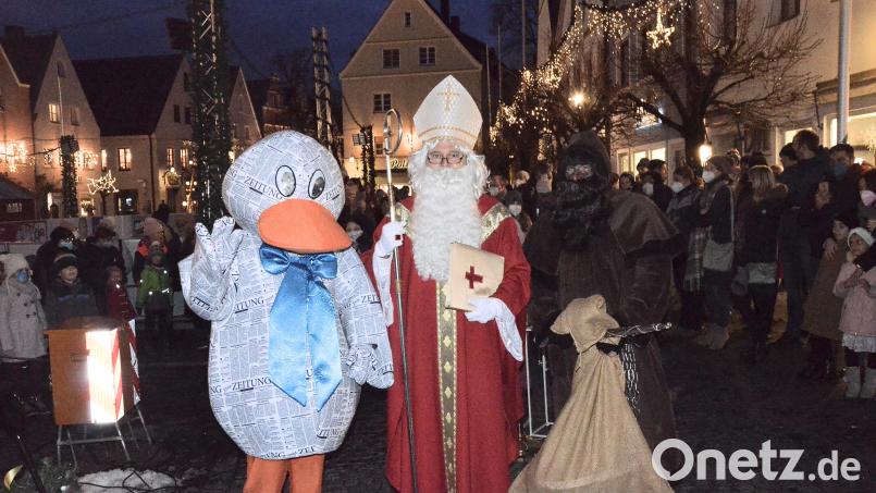 Der Nikolaus, umrahmt von Knecht Ruprecht und Paula Print, der Zeitungsente von Oberpfalz-Medien, öffnete am Sonntag das fünfte Türchen des Adventskalenders am Alten Rathaus. Bild: Kunz