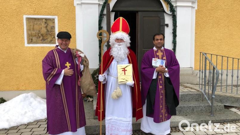 Diakon Rudolf Hoffmann (von links) und Pfarrer Anish George begleiteten den Heiligen Nikolaus nach dem Gottesdienst auf den Kirchplatz. Bild: soj