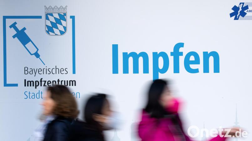 Passanten laufen an einem Impfzentrum in der Münchener Innenstadt vorbei. Symbolbild: Sven Hoppe