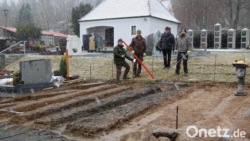 Die Pfarrei Michldorf kann für Urnenbeisetzungen auch weiterhin verschiedene Möglichkeiten anbieten, meint Pfarrer Alfons Forster (2.v.r.). Neben der Urnenwand (im Bild links neben dem Leichenhaus), den Urnenstelen (rechts vom Leichenhaus) und Urnengräbern im alten Friedhof werden nun 24 Plätze für Urnengräber im neuen Friedhof errichtet. Bild: grm