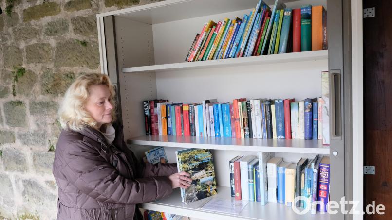 Familienbeauftragte und Gemeinderätin Anneliese Weber beim Einordnen von Büchern in den neuen öffentlichen Bücherschrank in Oberbibrach. Bild: do