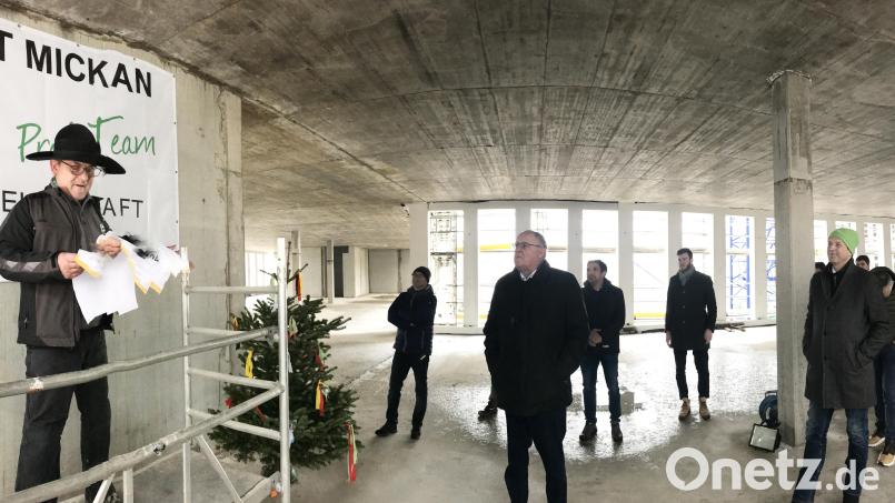 Im offenen Rohbau verliest Markus Günther auf einem kleinen Podest den Richtspruch. Bild: Gabi Schönberger