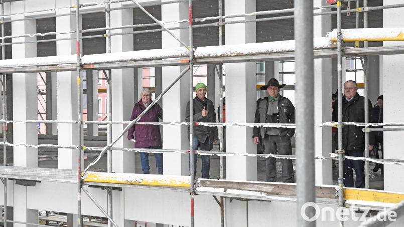 In der klar gegliederten Fertigbetonfassade der künftigen AOK Geschäftsstelle stehen Gaby Hübner (von links), Jürgen Spickenreuther, Polier Markus Günther und Lothar Höher beim dezemberlichen Richtfest fast wie in einem großen Adventskalender. Bild: Gabi Schönberger
