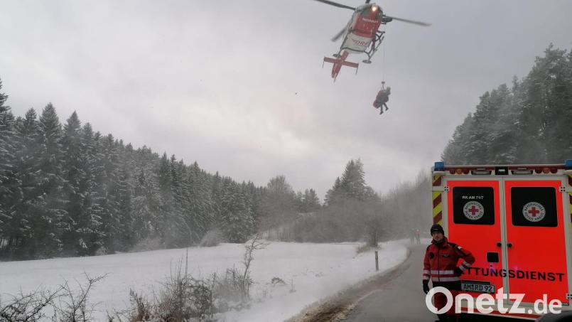 Auf dem Bild ist zu sehen, wie der im Luftrettungssack verpackte Patient zusammen mit der Luftretterin der Bergwacht nach erfolgreicher Rettung aus dem unwegsamen Gelände neben den bereitstehenden Rettungswagen abgelassen wird. Bild: Maximilian Knab (Bergwacht Amberg)]
