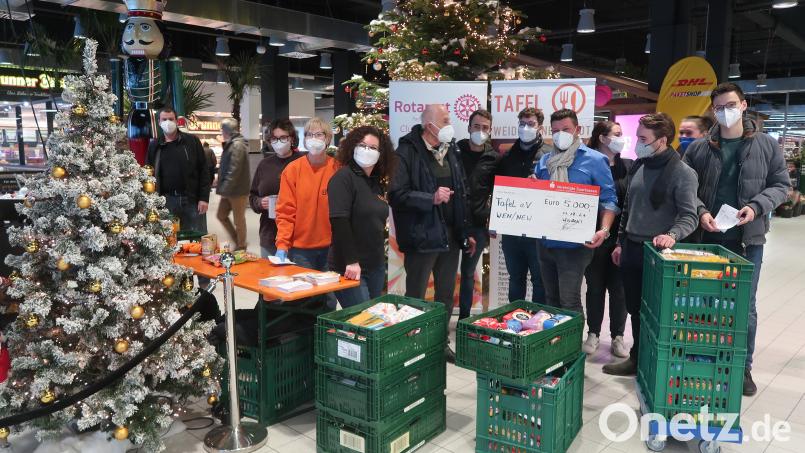 Klaus Grünbauer überreicht einen Scheck in Höhe von 5000 Euro an &quot;Die Tafel&quot;. Rotarac-Mitglieder sammeln Lebensmittel. Bild: Kunz
