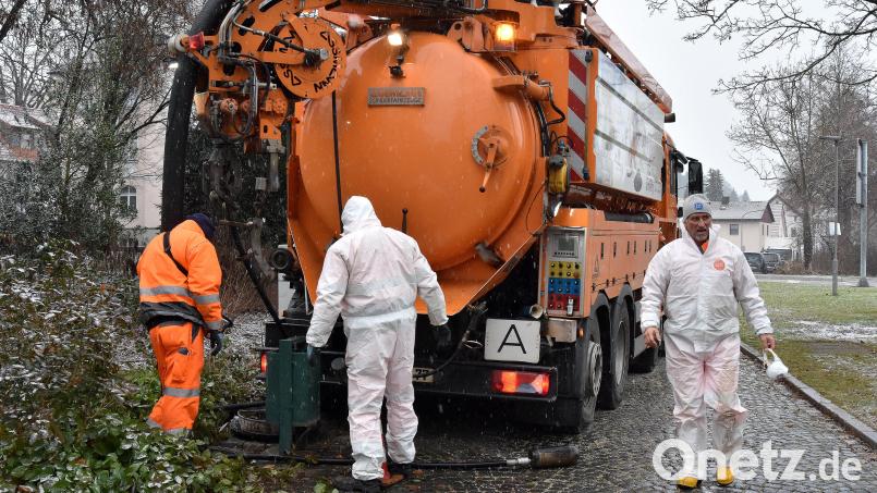 Kanalreinigung am Maxplatz. Weil sie hier in die Tiefe steigen müssen, schützen sich die Arbeiter des städtischen Betriebshofs mit Schutzanzügen und Maske. Bild: Stephan Huber